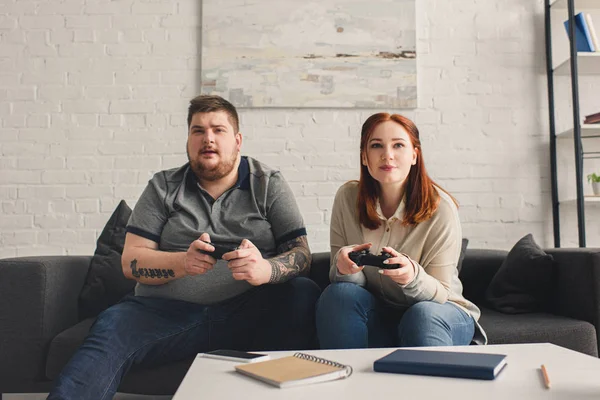 Pareja con sobrepeso jugando videojuego - foto de stock