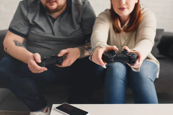 Cropped image of boyfriend and girlfriend playing video game at home — Stock Photo