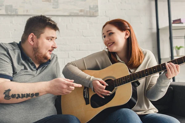 Fidanzata suonare la chitarra per il fidanzato a casa — Foto stock