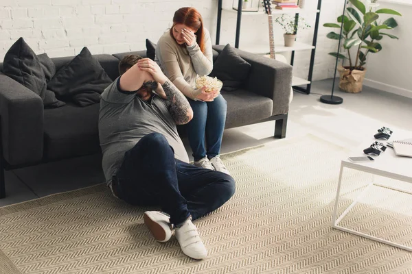Boyfriend and girlfriend closing eyes while watching horror movie at home — Stock Photo