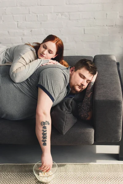 Novio y novia durmiendo en el sofá en casa - foto de stock