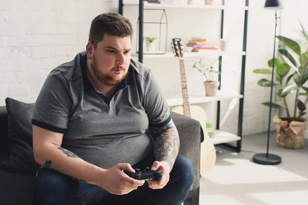 Overweight man playing video game — Stock Photo