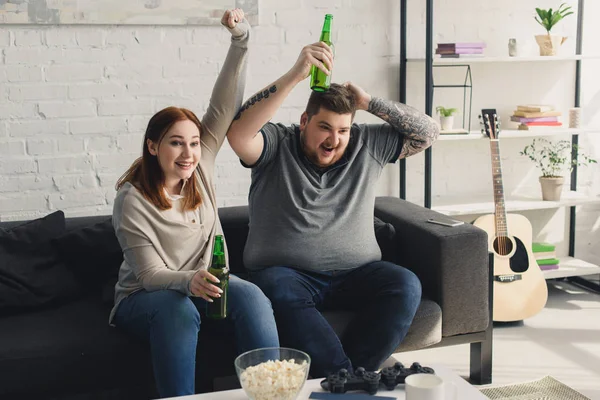 Happy boyfriend and girlfriend showing yes gesture while watching football at home — Stock Photo