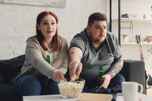 Overweight couple taking popcorn — Stock Photo