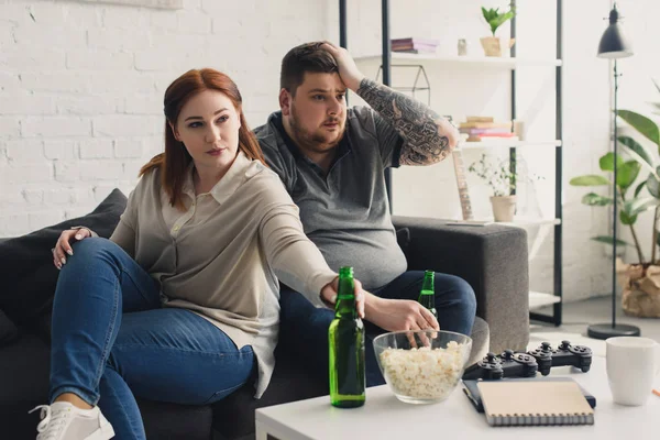 Size plus boyfriend and girlfriend watching tv at home — Stock Photo
