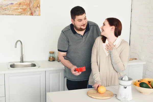 Tamaño más novio regalo de regalo a la novia en la cocina - foto de stock