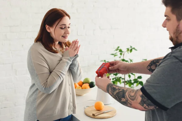 Petit ami cadeau de présentation à petite amie à la cuisine — Photo de stock