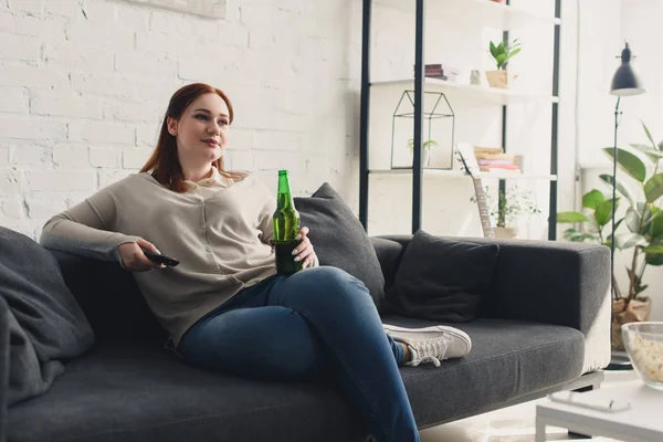 Chica con sobrepeso viendo la televisión - foto de stock