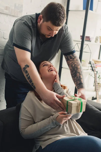 Boyfriend presenting gift to girlfriend at home — Stock Photo