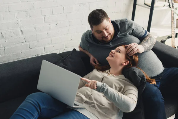 Novio tocando novia pelo y ellos mirando el uno al otro en casa - foto de stock