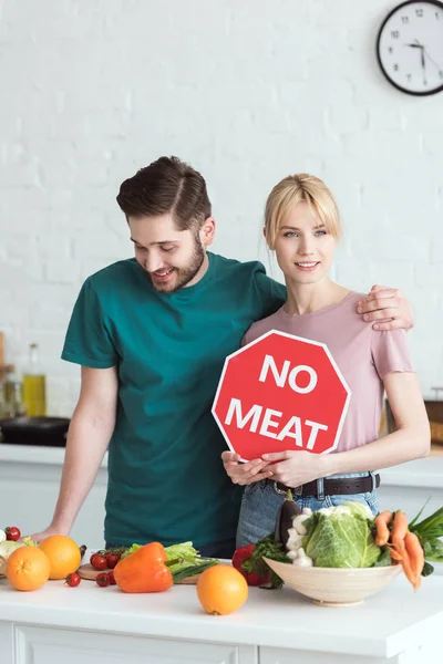 Couple of vegans with no meat sign at kitchen — Stock Photo