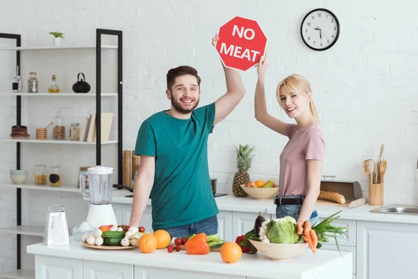 Пара вегетарианцев, не показывающих мясной знак на кухне — стоковое фото