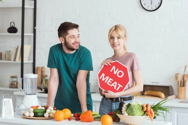 Пара вегетарианцев, стоящих без таблички с мясом на кухне — стоковое фото