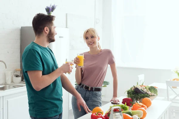 Pareja de veganos hablando en la cocina y la celebración de jugo - foto de stock