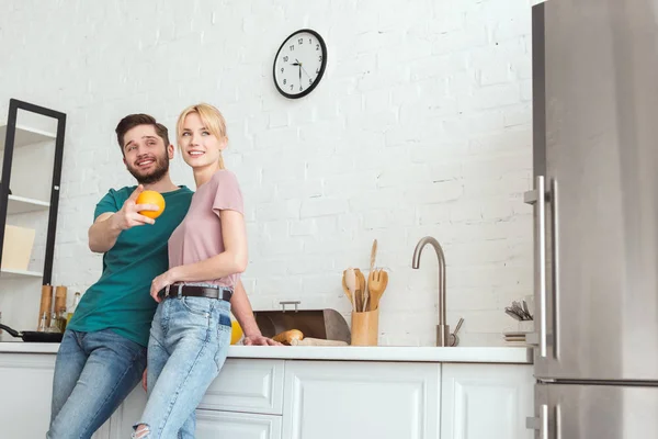 Par de vegans abraçando e olhando para a cozinha — Fotografia de Stock