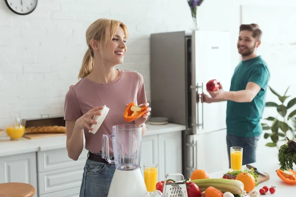 Couple of vegans smiling while cooking at kitchen — Stock Photo