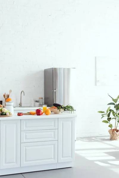 Innenraum der hellen modernen Küche mit Obst und Gemüse auf dem Küchentisch — Stockfoto