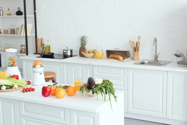 Interior da cozinha moderna branca com frutas e legumes no balcão da cozinha — Fotografia de Stock