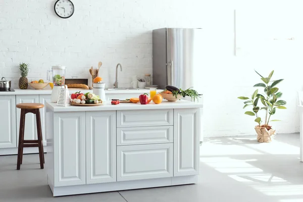 Interior de la cocina de luz blanca con frutas y verduras en el mostrador de cocina — Stock Photo