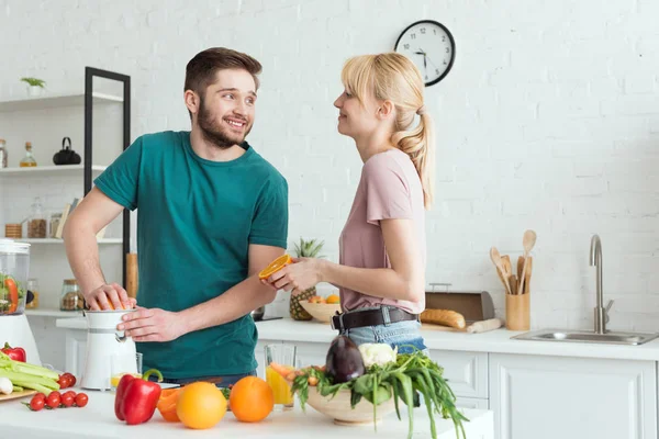 Namorado preparando suco fresco na cozinha, conceito vegan — Fotografia de Stock