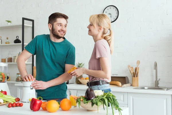 Novio preparando jugo fresco en la cocina, concepto vegano - foto de stock