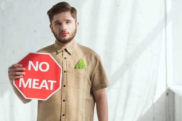 Portrait of man with no meat sign and savoy cabbage leaf in pocket, vegan lifestyle concept — Stock Photo