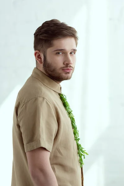 Vue latérale du jeune homme avec cravate en roquette regardant la caméra, concept de style de vie végétalien — Photo de stock
