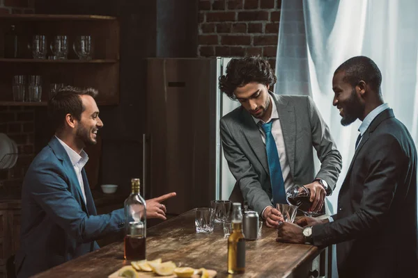 Красиві молоді друзі-чоловіки п'ють алкогольні напої і розмовляють під час вечірки разом — стокове фото