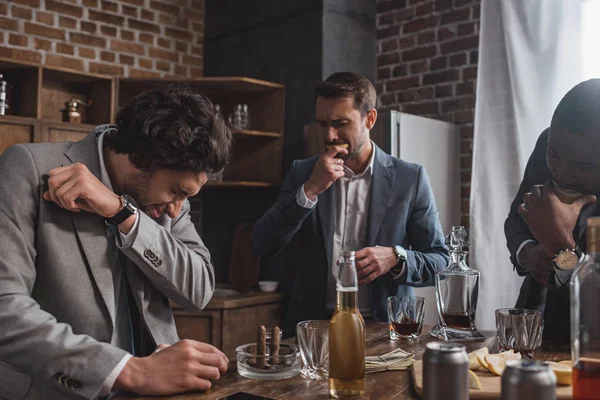 Empresários multiétnicos comendo fatias de limão e bebendo tequila juntos — Fotografia de Stock