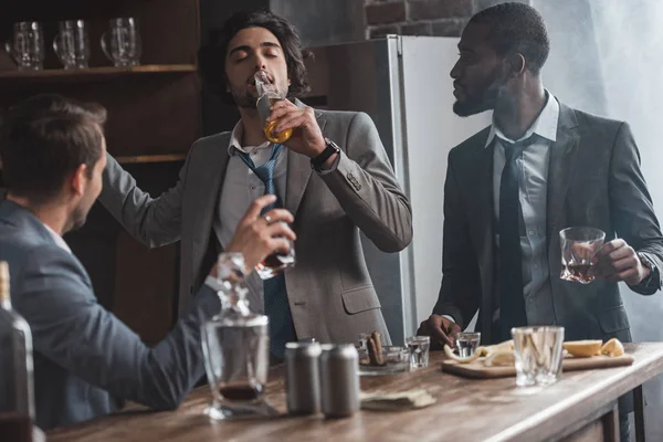 Молодые мультиэтнические бизнесмены пьют алкогольные напитки вместе — стоковое фото