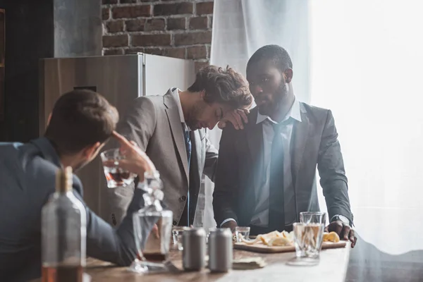 Betrunkene multiethnische Männer in offizieller Kleidung trinken Alkohol — Stockfoto