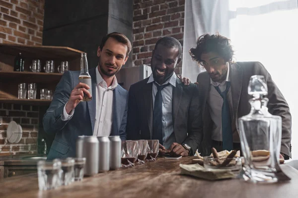 Young multiethnic businessmen drinking alcohol beverages together — Stock Photo