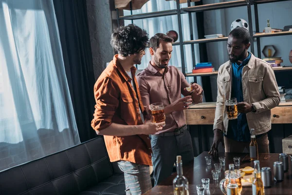 Jóvenes hombres multiétnicos bebiendo cerveza y festejando juntos — Stock Photo