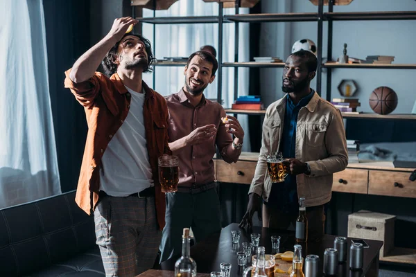 Jeunes amis masculins multiethniques buvant de la bière et faisant la fête ensemble — Photo de stock