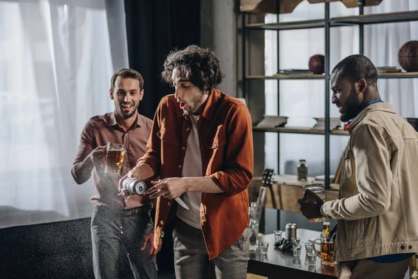 Feliz joven hacer amigos beber cerveza juntos en el interior — Stock Photo