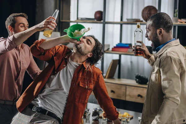 Drunk male friends drinking alcohol beverages from funnel at party — Stock Photo