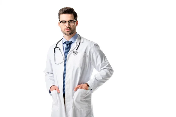 Médico varón confiado que usa bata blanca con estetoscopio aislado en blanco - foto de stock