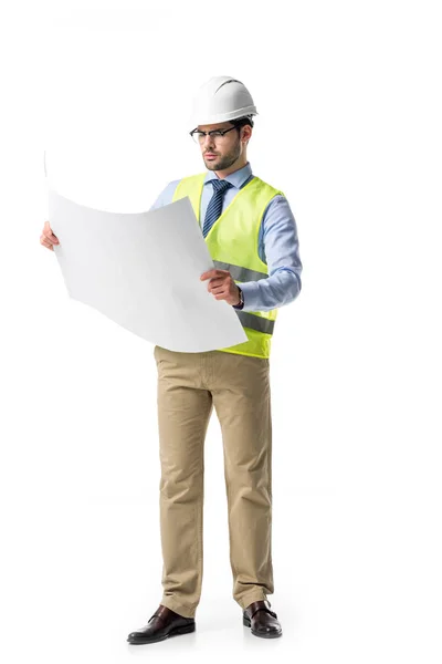 Thoughtful builder in reflective vest and helmet looking at blueprint isolated on white — Stock Photo