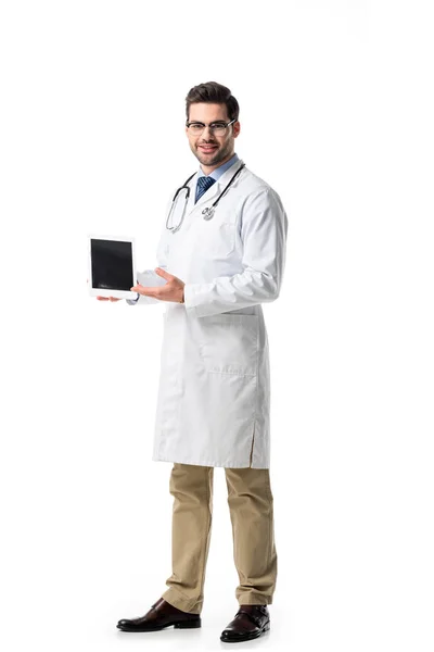 Doctor en gafas con abrigo blanco con estetoscopio que presenta tableta digital aislada en blanco - foto de stock