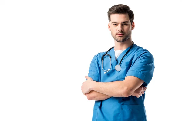 Chirurgo in uniforme blu con stetoscopio in piedi con braccia incrociate isolate su bianco — Foto stock