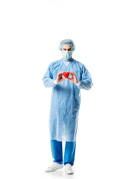 Surgeon wearing blue uniform and holding toy heart isolated on white — Stock Photo