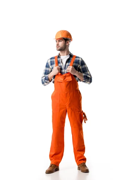 Selbstbewusster Handwerker in orangefarbenem Overall und Helm auf weißem Grund — Stockfoto