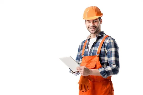 Constructeur souriant dans l'ensemble orange et casque dur en utilisant une tablette numérique isolée sur blanc — Photo de stock