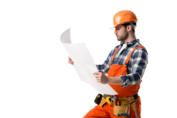 Reparateur in orangefarbenem Overall und Helm schaut auf Blaupause isoliert auf weißem Grund — Stockfoto
