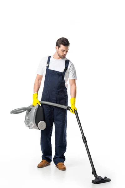 Cleaner in uniform and rubber gloves with vacuum cleaner isolated on white — Stock Photo