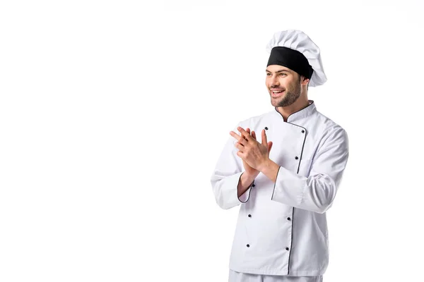 Retrato de chef sonriente en uniforme y sombrero mirando hacia otro lado aislado en blanco - foto de stock