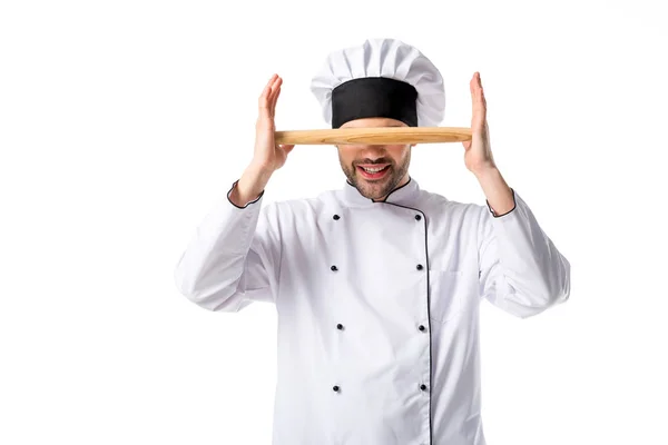 Obscured view of chef in uniform with wooden rolling pin isolated on white — Stock Photo