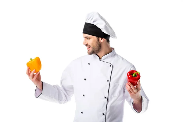 Chef sorridente in uniforme con peperoni freschi in mano isolati su bianco — Foto stock