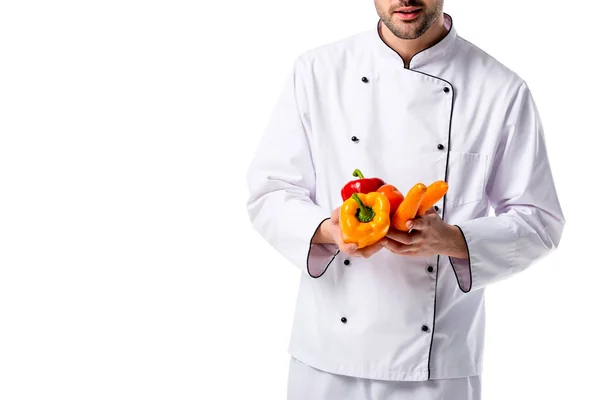 Vista parziale dello chef in uniforme con verdure fresche in mano isolate su bianco — Foto stock