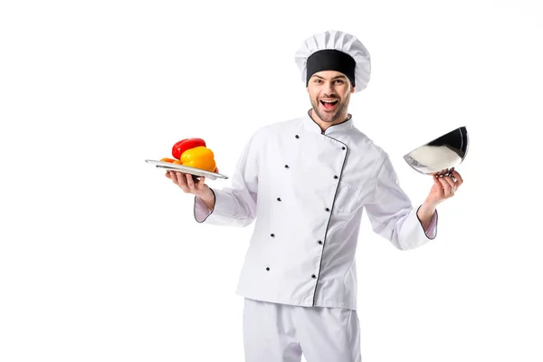 Smiling chef with fresh bell peppers on serving tray isolated on white — Stock Photo